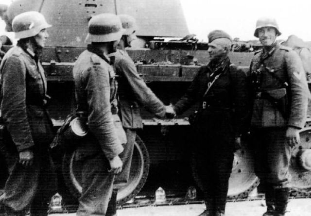 Soldados alemanes saludando a un jefe de carro soviético BT-7